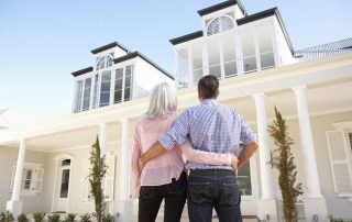 Couple standing in front of recently purchased home